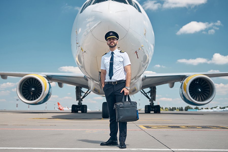 cheerful-male-pilot-standing-outdoors-in-airfield-KG53T58p.jpg