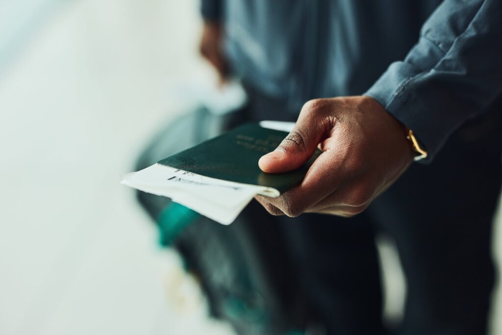 Shot of an unrecognizable person holding his passport indoors